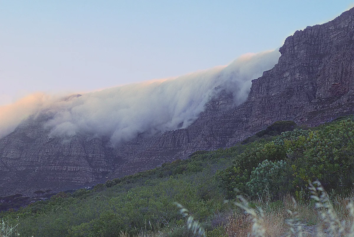 The tablecloth cloud spilling over the sandstone strata of Table Mountain, Cape Town