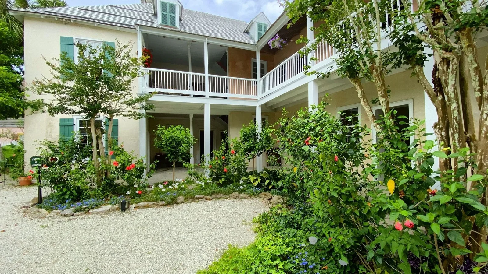 Two-story historic house with balconies and a flower garden in St. Augustine, Florida.