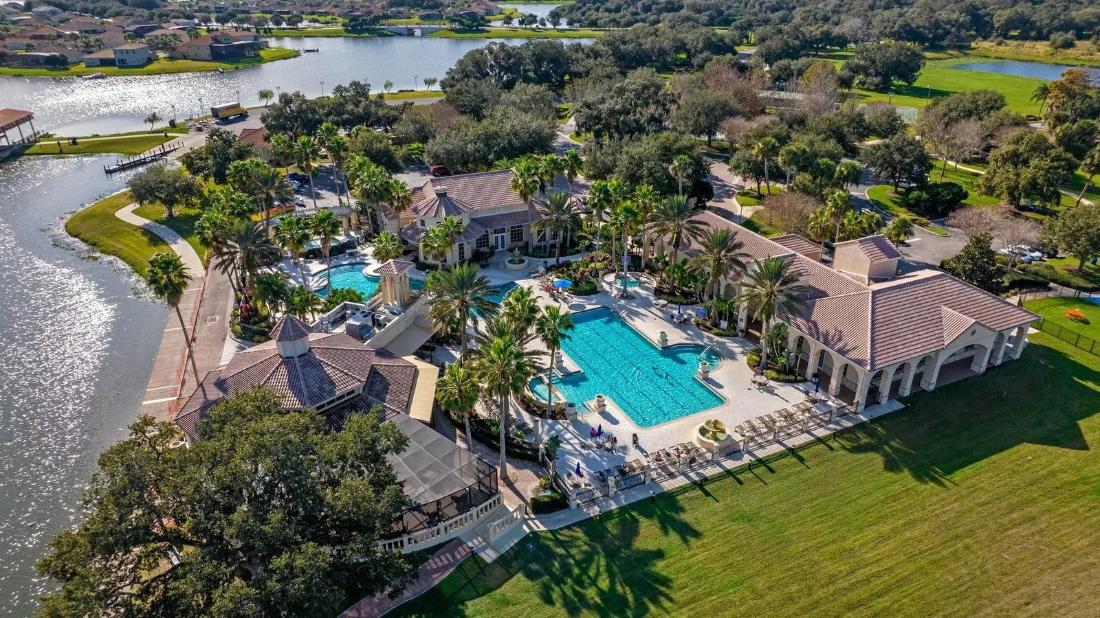 Aerial view of the Bellalago clubhouse and pool complex beside the water in Kissimmee.