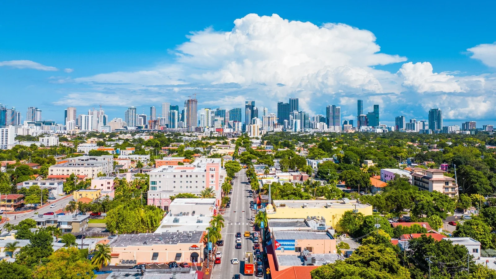 Aerial view of low-rise Miami neighbourhoods with the downtown skyline on the horizon