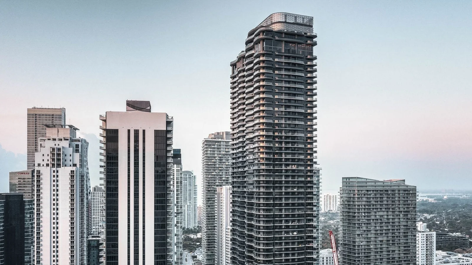 The dark curved Brickell Flatiron tower rising above neighbouring Brickell high-rises.