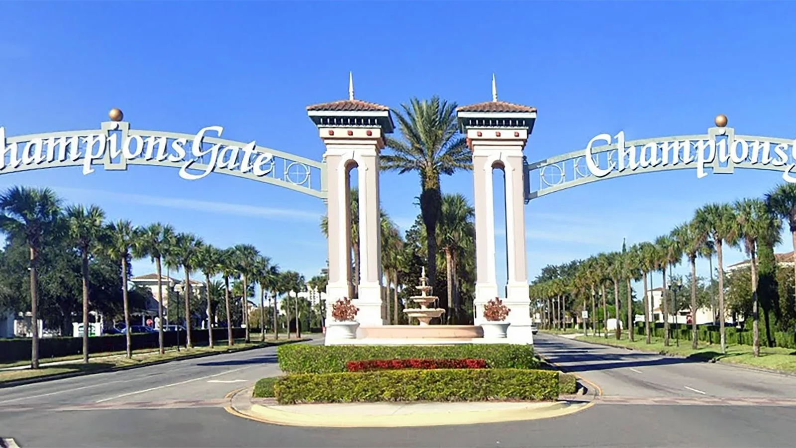 Twin-tower entrance arches bearing the ChampionsGate name over a palm-lined boulevard.