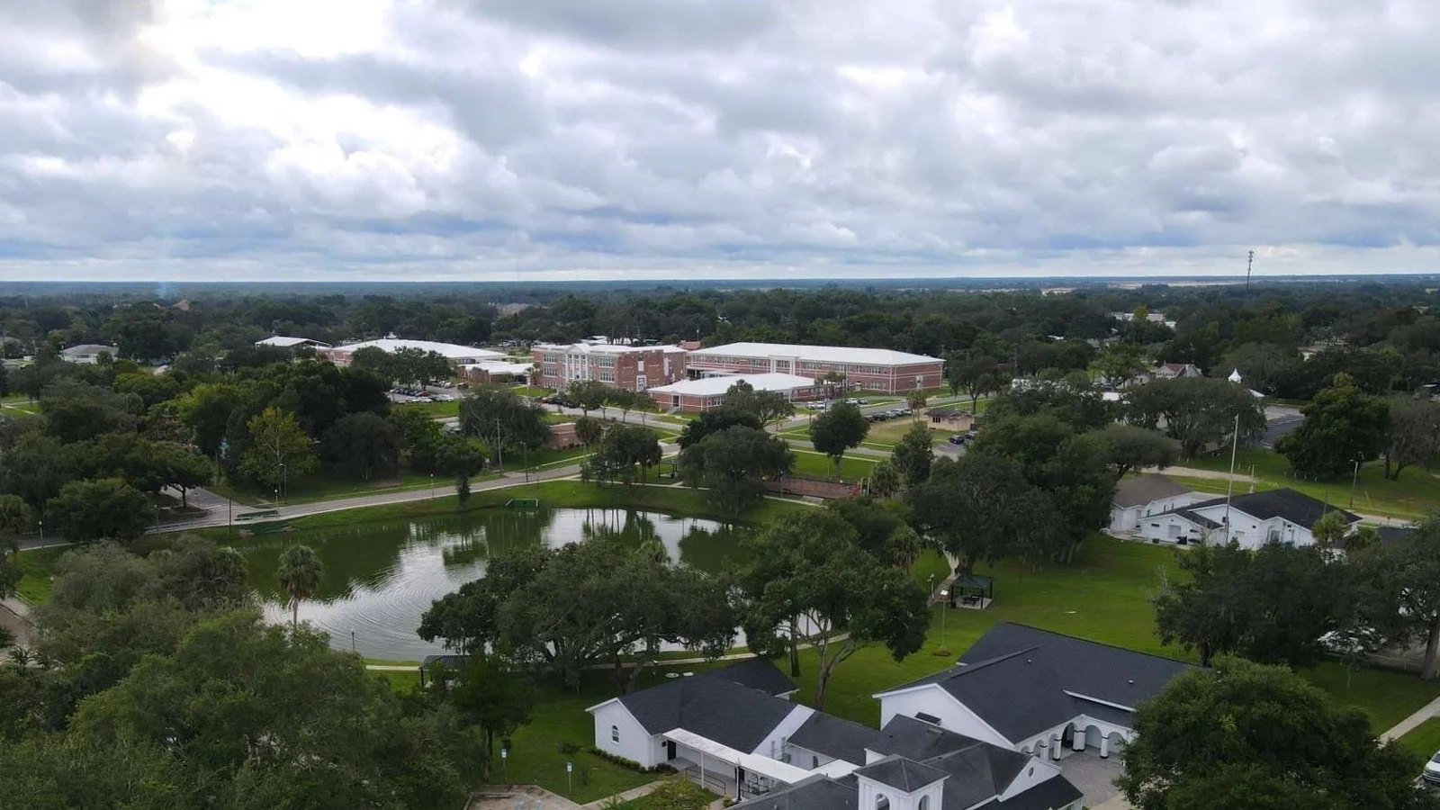 Aerial view of Davenport with a park pond and tree-lined streets, the town where Cypress Pointe Forest is located, shown in place of the community itself.