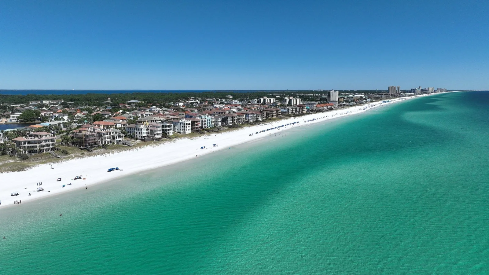 Aerial view of the Destin shoreline with white sand, emerald water and beachfront homes