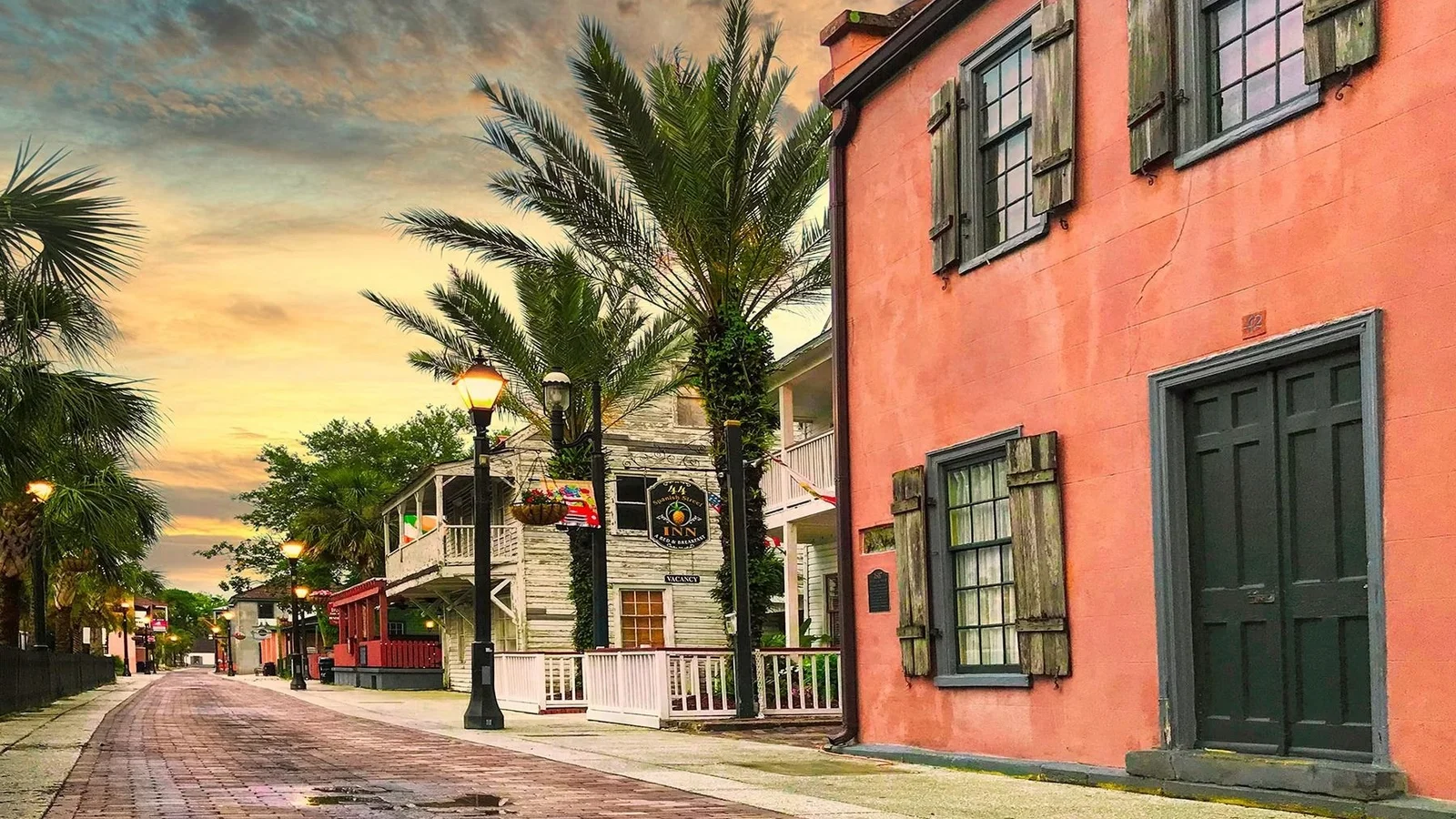 Historic buildings and palms along brick-paved Spanish Street in St. Augustine, Florida.