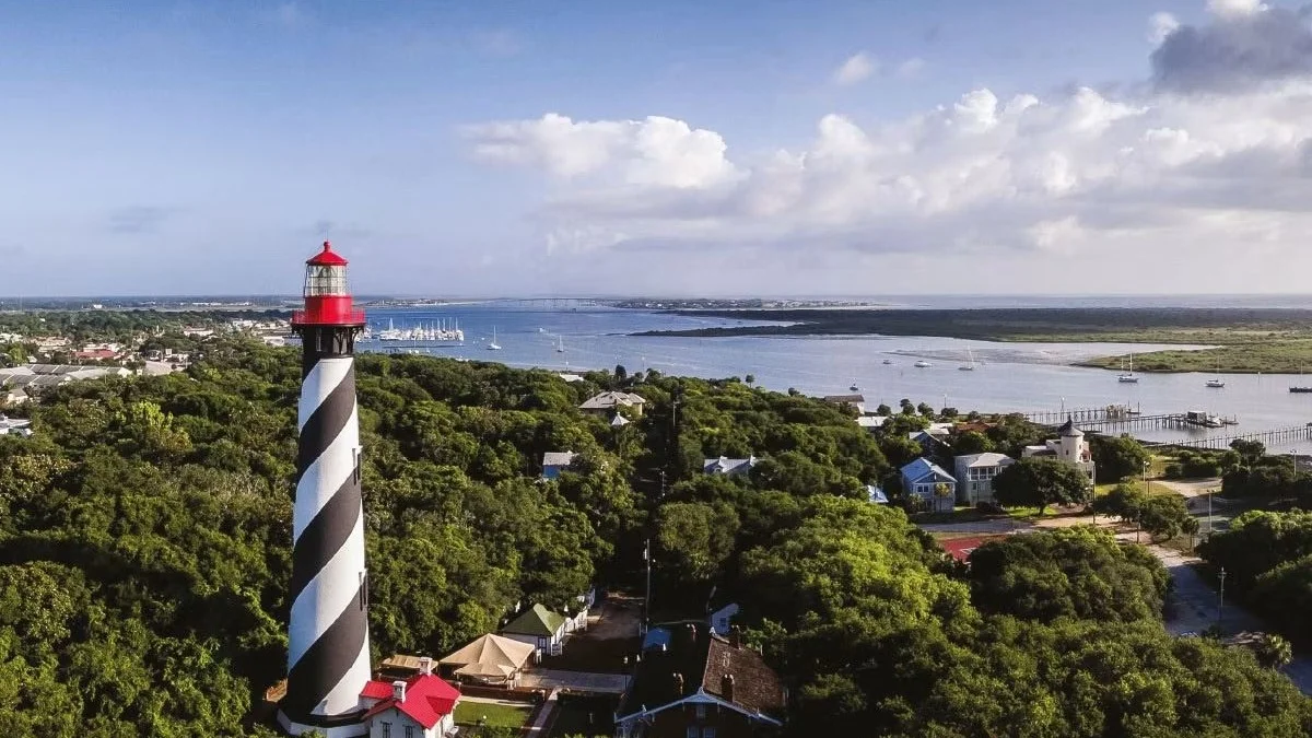 Aerial view of the St. Augustine Lighthouse above wooded homes on Anastasia Island.