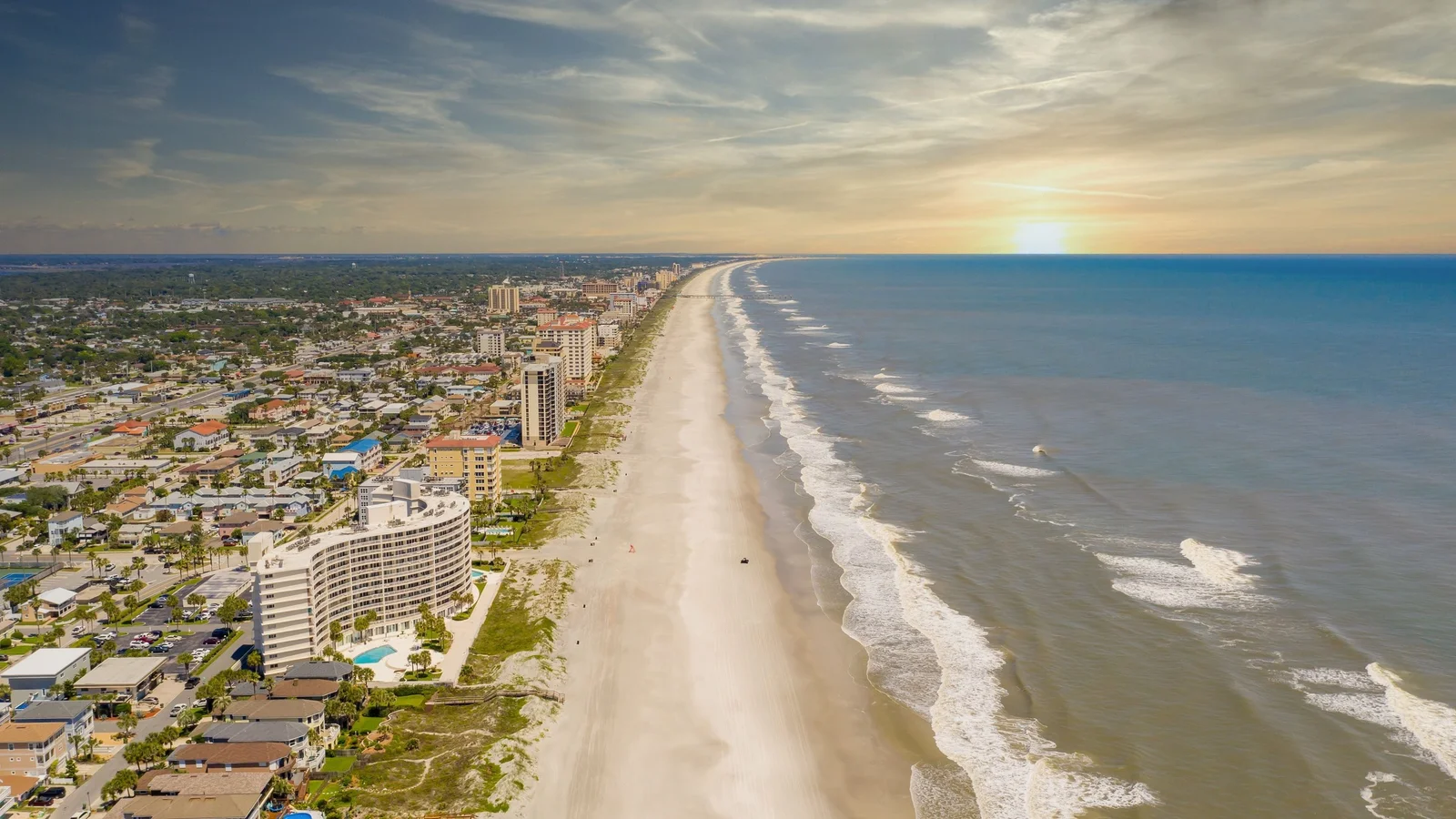 Aerial view of Jacksonville Beach with oceanfront condos and the Atlantic surf at sunrise