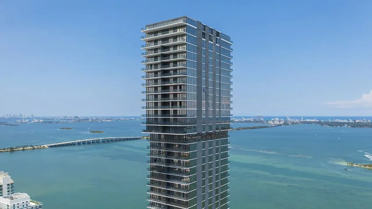 The upper floors of the slim Elysee tower in Edgewater, with Biscayne Bay and a causeway stretching behind it.