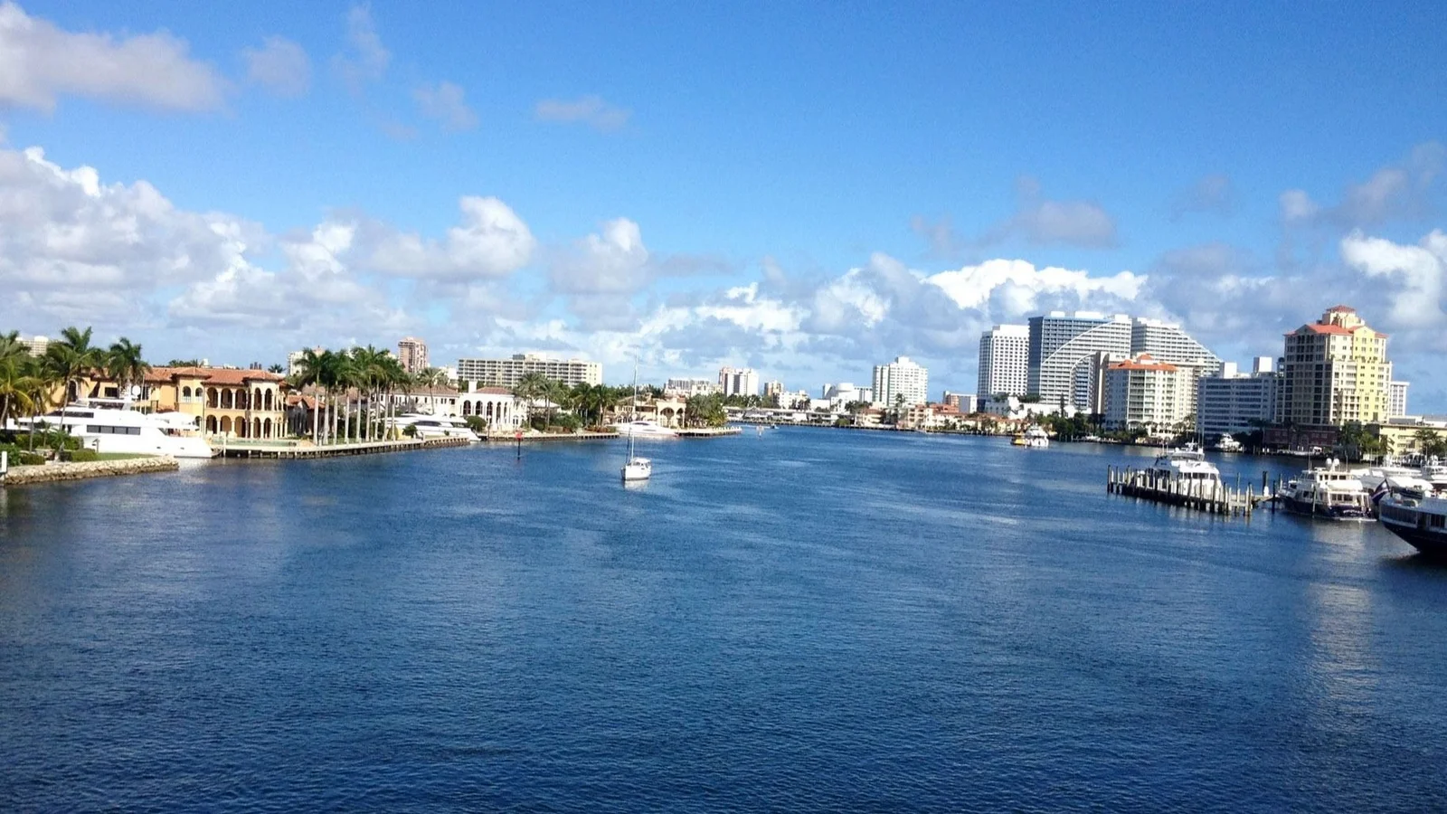 Waterfront homes and yachts on the Intracoastal Waterway in Fort Lauderdale with beach towers behind