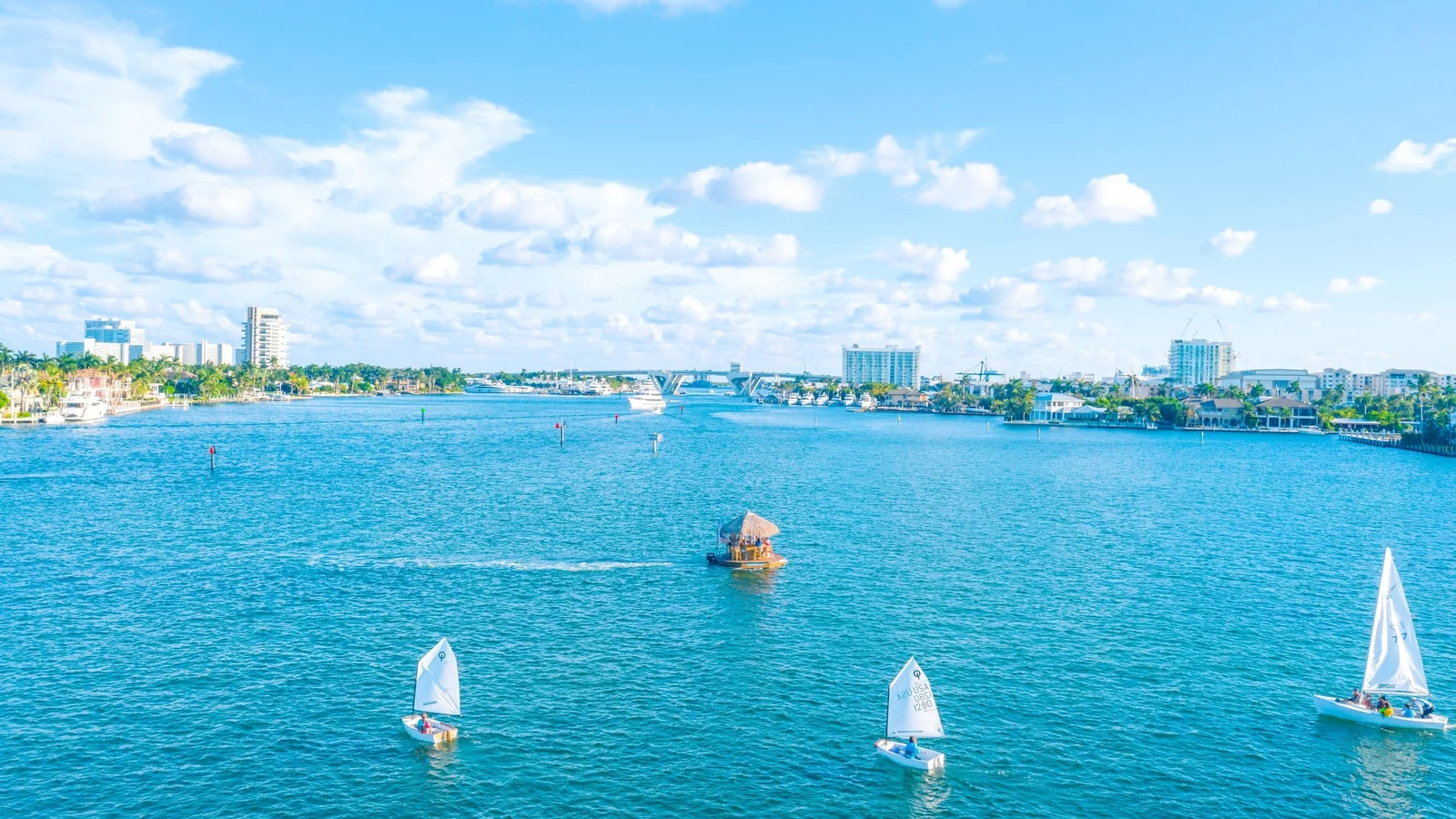 Boats and sailboats on the Intracoastal Waterway in Fort Lauderdale with waterfront homes and towers