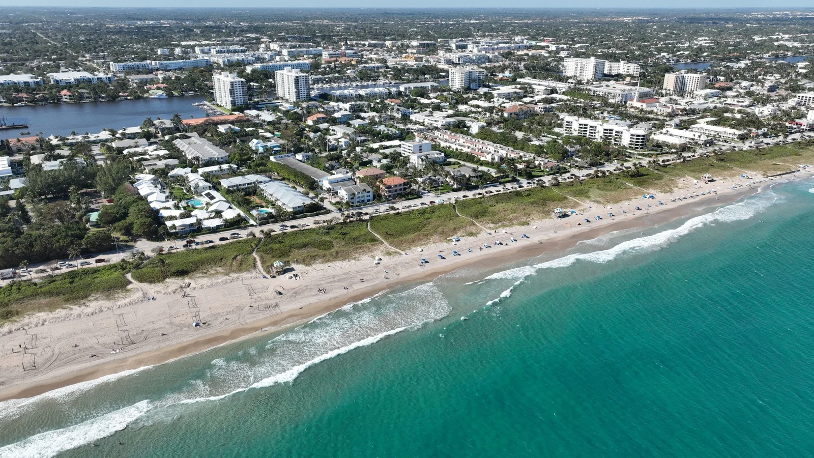 Aerial view of the Delray Beach shoreline with homes and low-rise buildings behind the beach