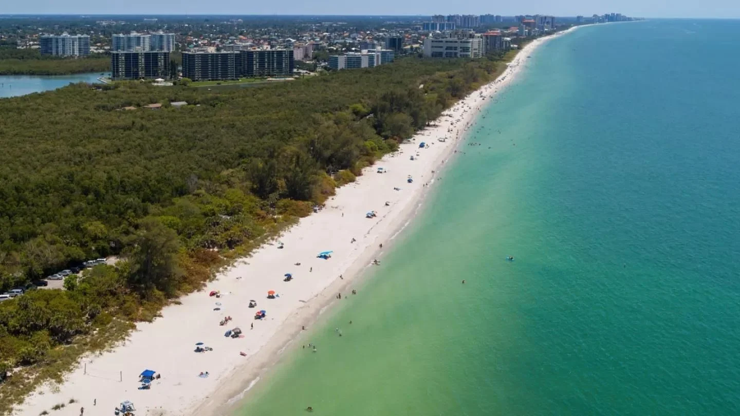 Aerial view of the beach at Delnor-Wiggins Pass State Park with North Naples condo towers.