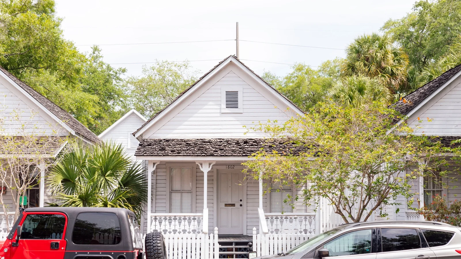 White wood-frame cottage with a porch and picket fence in Tampa, Florida.