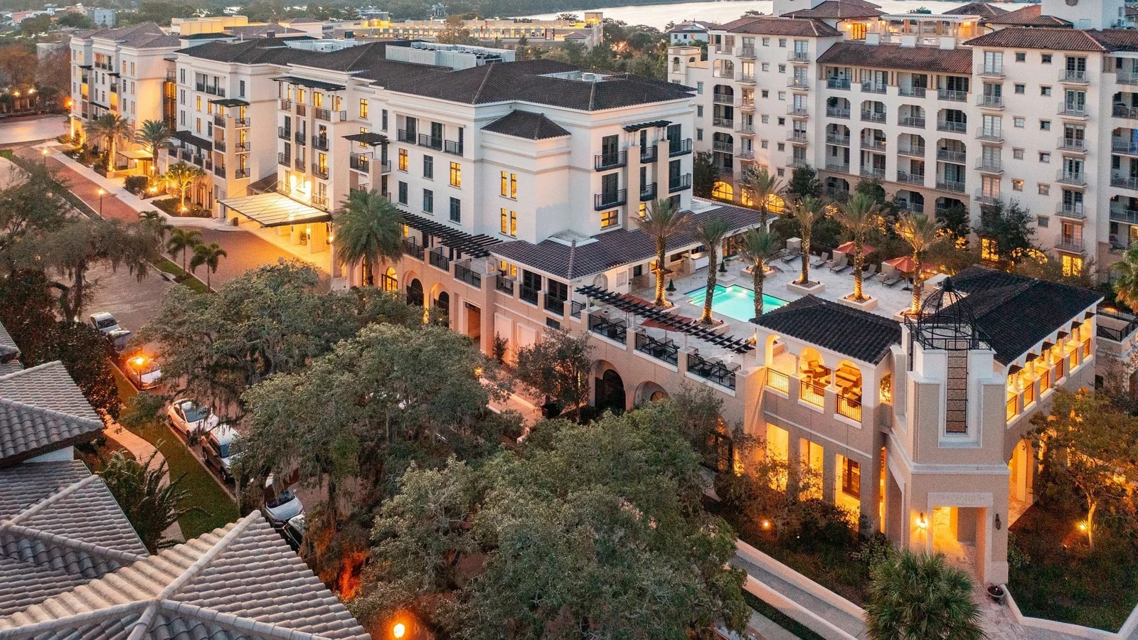 Evening aerial of mid-rise buildings with a rooftop pool in Winter Park, near Orlando.