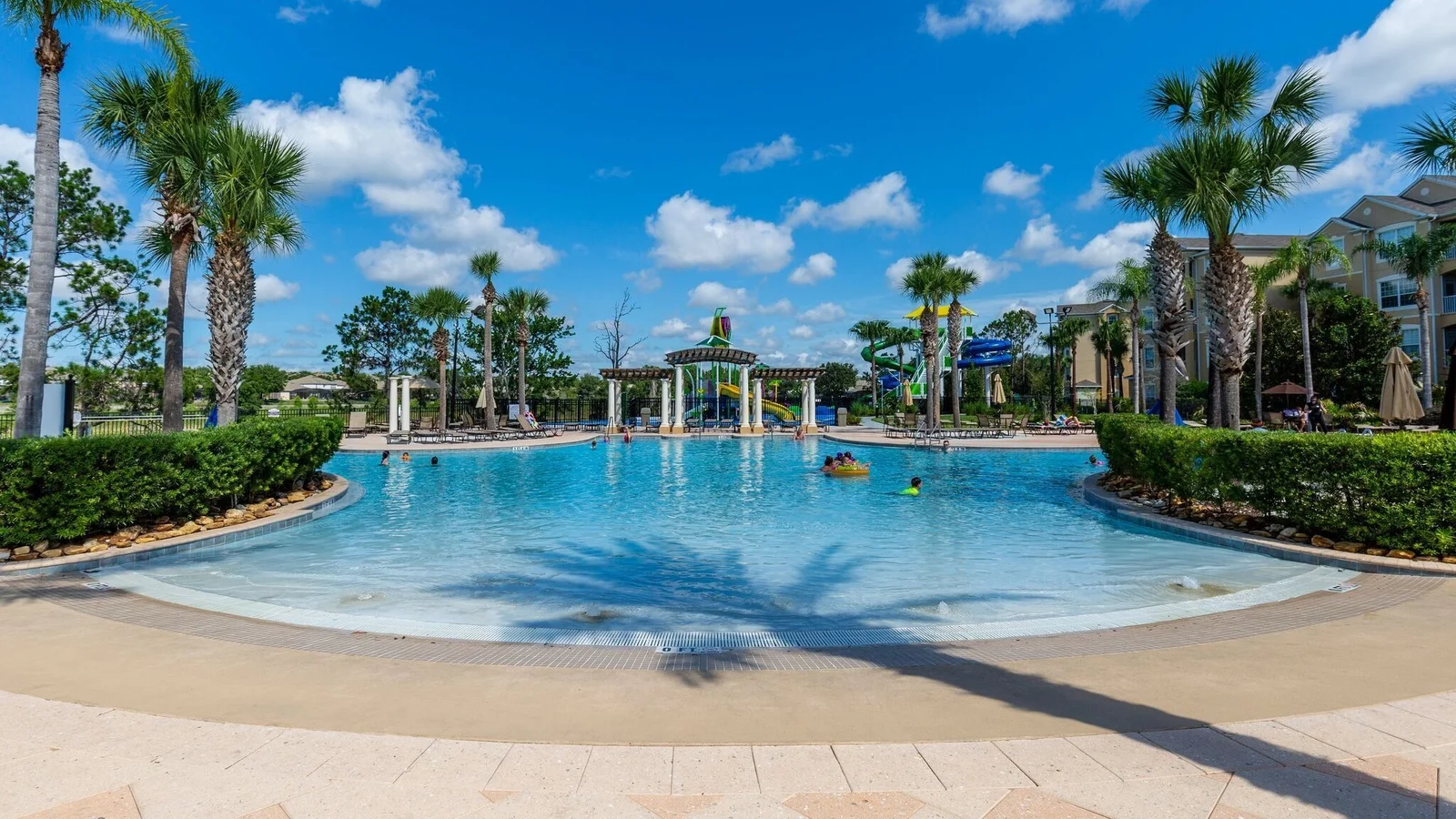 Beach-entry resort pool framed by palm trees at Windsor Hills in Kissimmee.