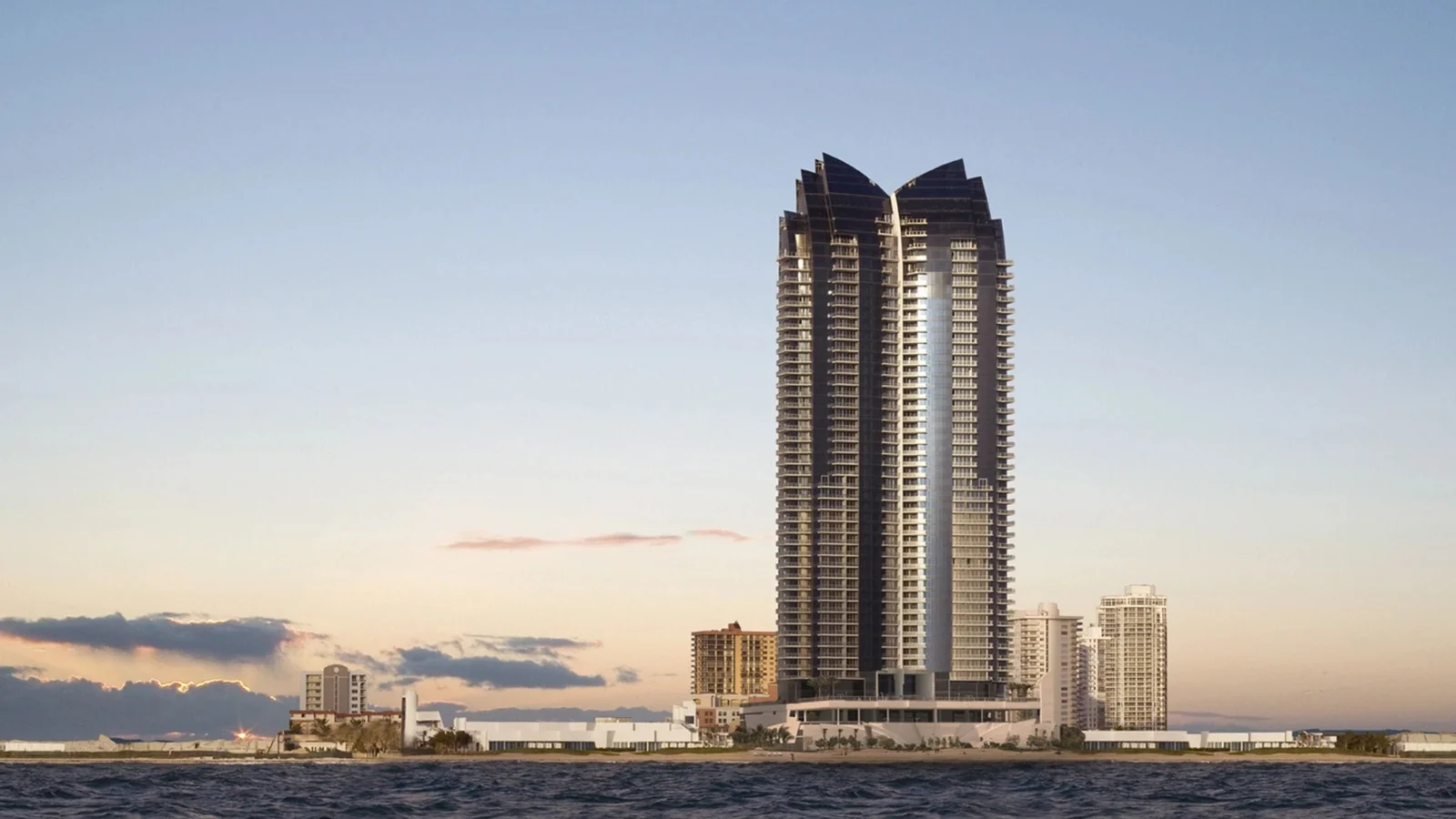 Jade Ocean tower with its twin-peaked crown seen from the ocean at dusk in Sunny Isles Beach