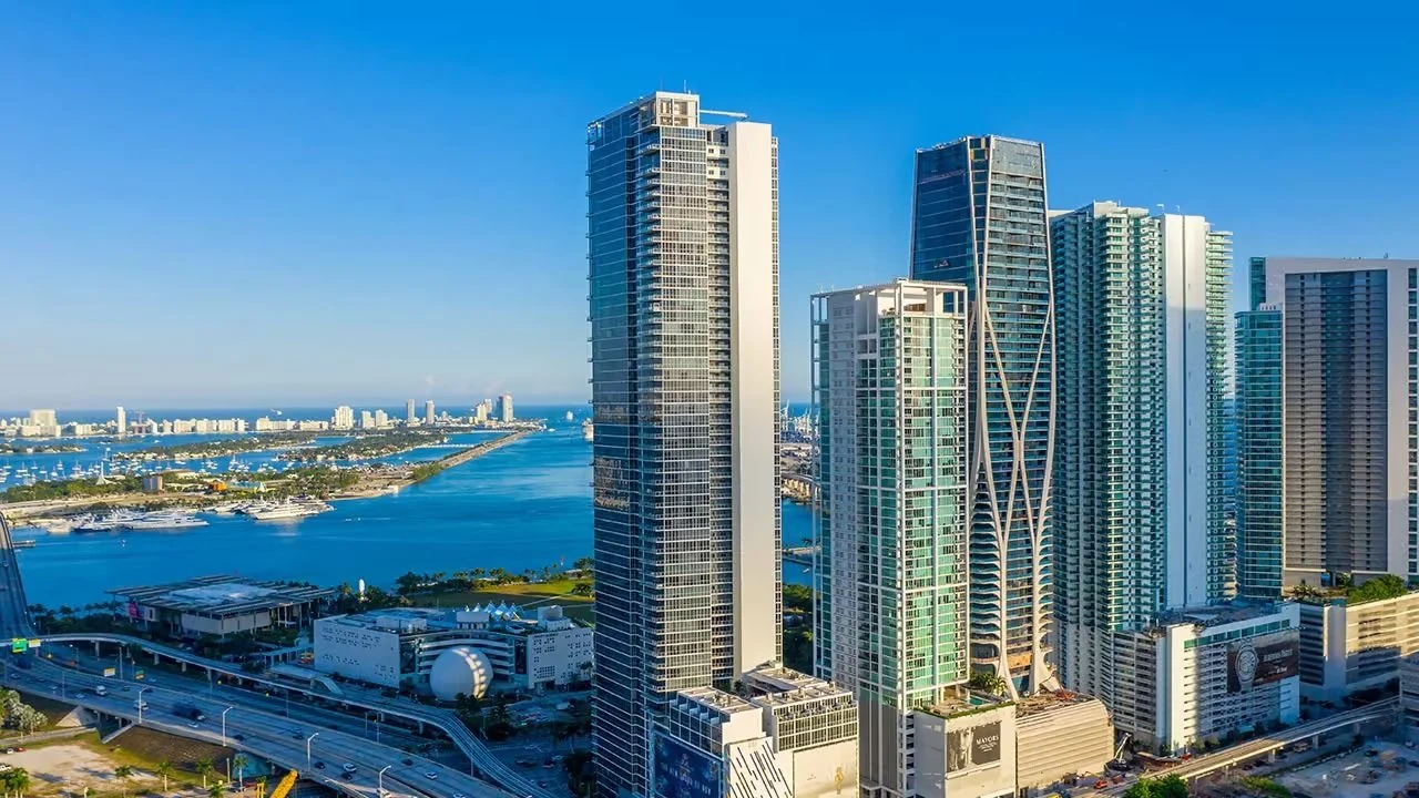 The tall, slim Marquis tower among neighbouring high-rises on Biscayne Boulevard, with Biscayne Bay and its islands on the left.