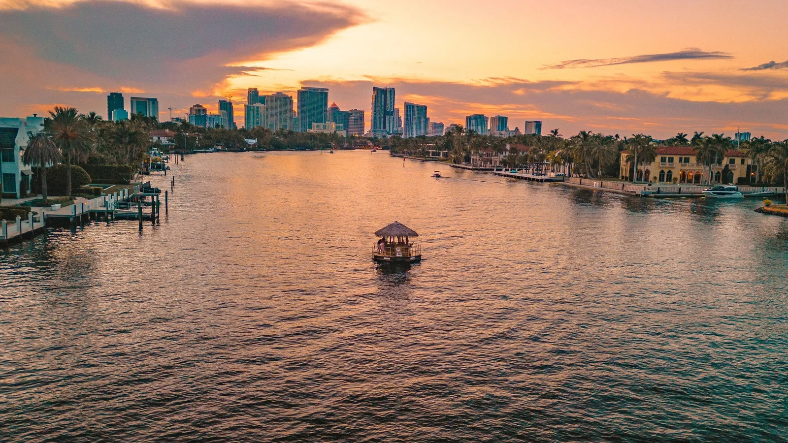 Fort Lauderdale skyline over the Intracoastal Waterway at sunset with a tiki boat