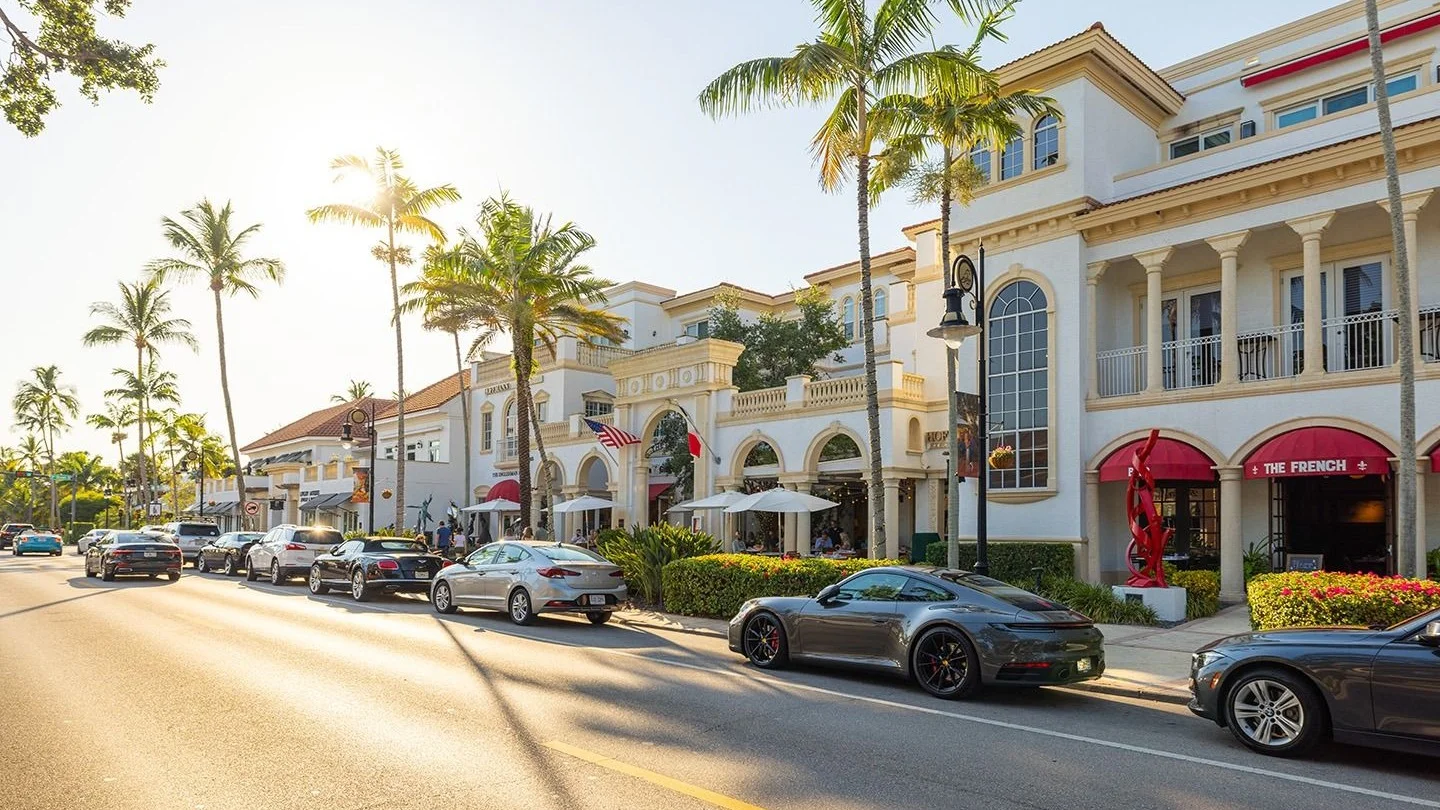 Shops and restaurants along palm-lined Fifth Avenue South in downtown Naples, Florida.