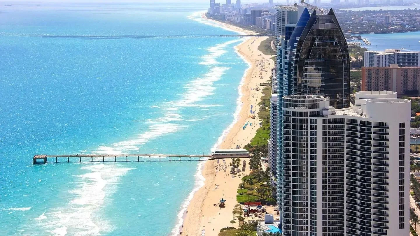 Aerial view of Sunny Isles Beach condo towers and pier on the Atlantic