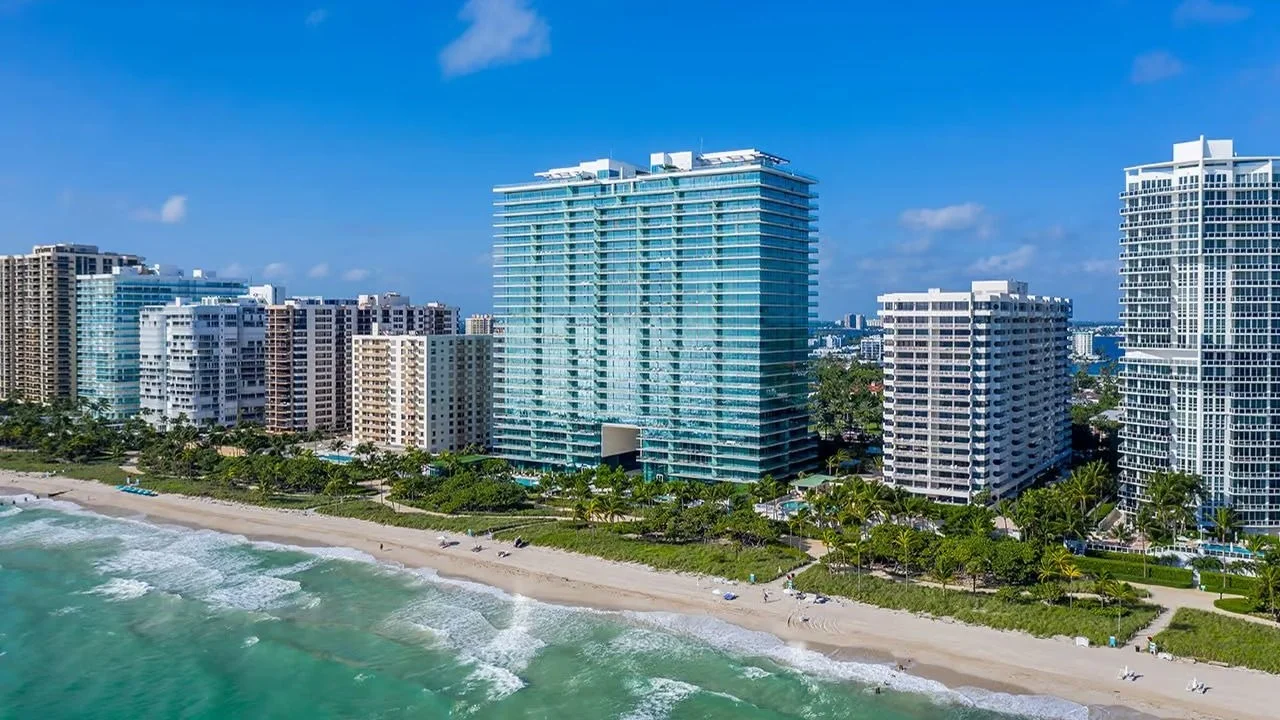 Oceana Bal Harbour glass tower on the beach among neighbouring condominium buildings