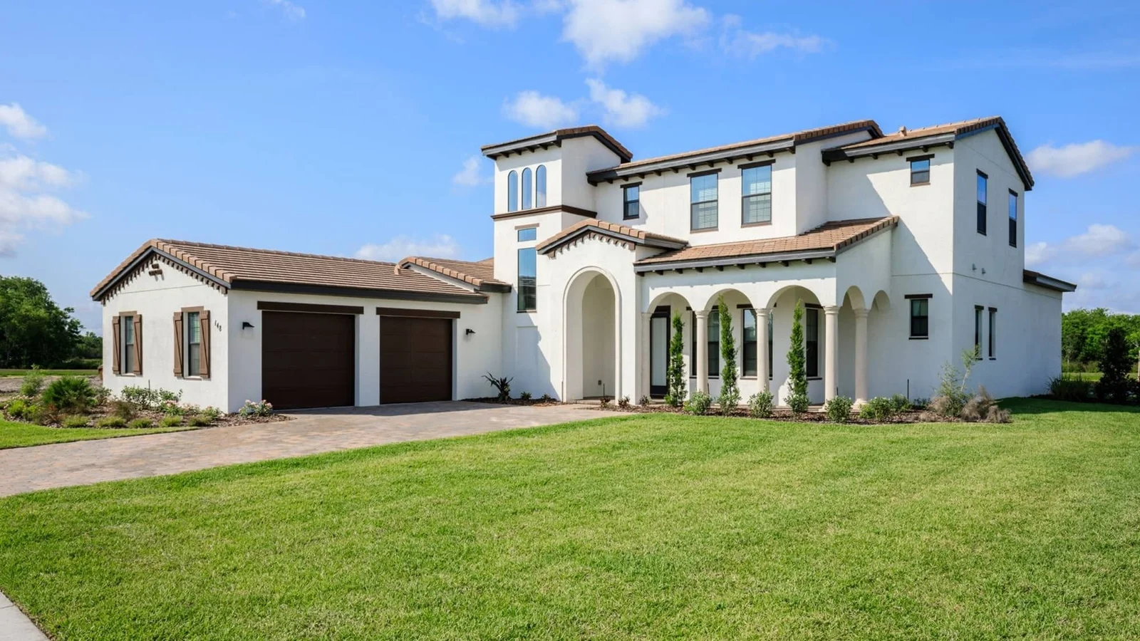 Two-story white Mediterranean-style vacation home with an attached garage at Balmoral Resort in Haines City.