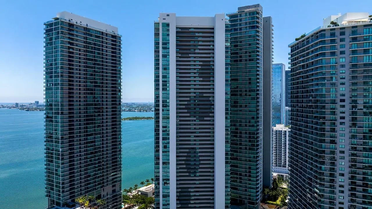 The dark glass Paraiso Bay tower with neighbouring Paraiso District towers in Edgewater and Biscayne Bay behind.