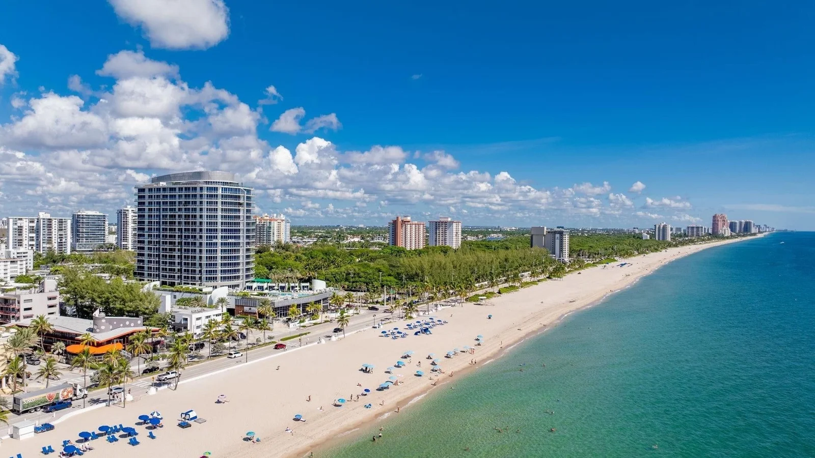 Aerial view of Fort Lauderdale Beach with the round Paramount tower beside the Bonnet House woods