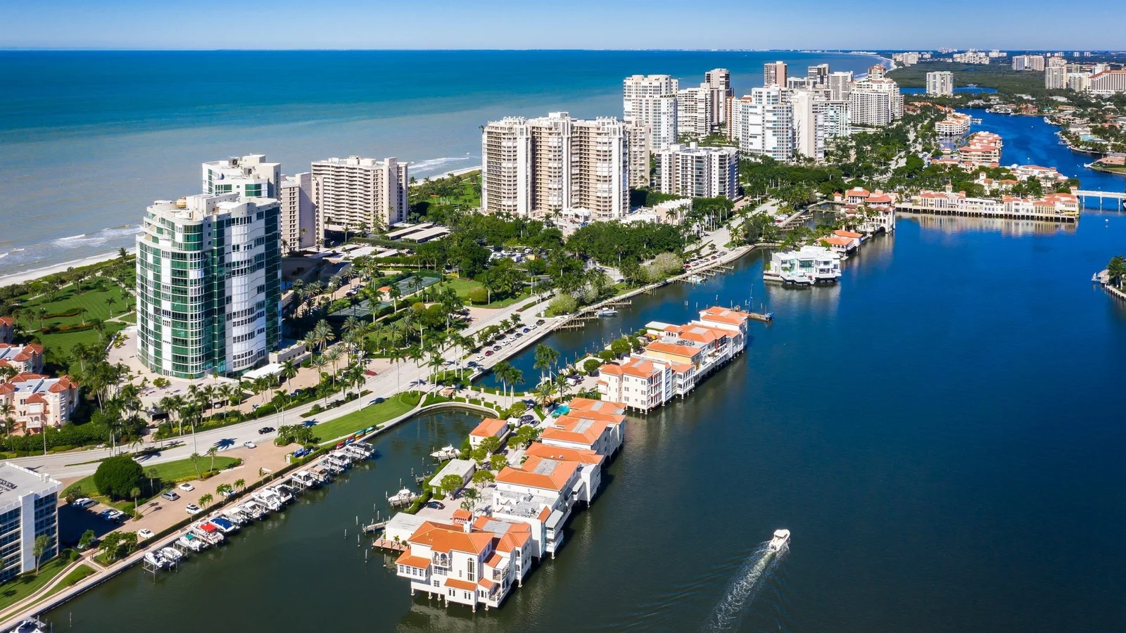 Aerial view of Park Shore in Naples with condominium towers on the Gulf and the Village on Venetian Bay