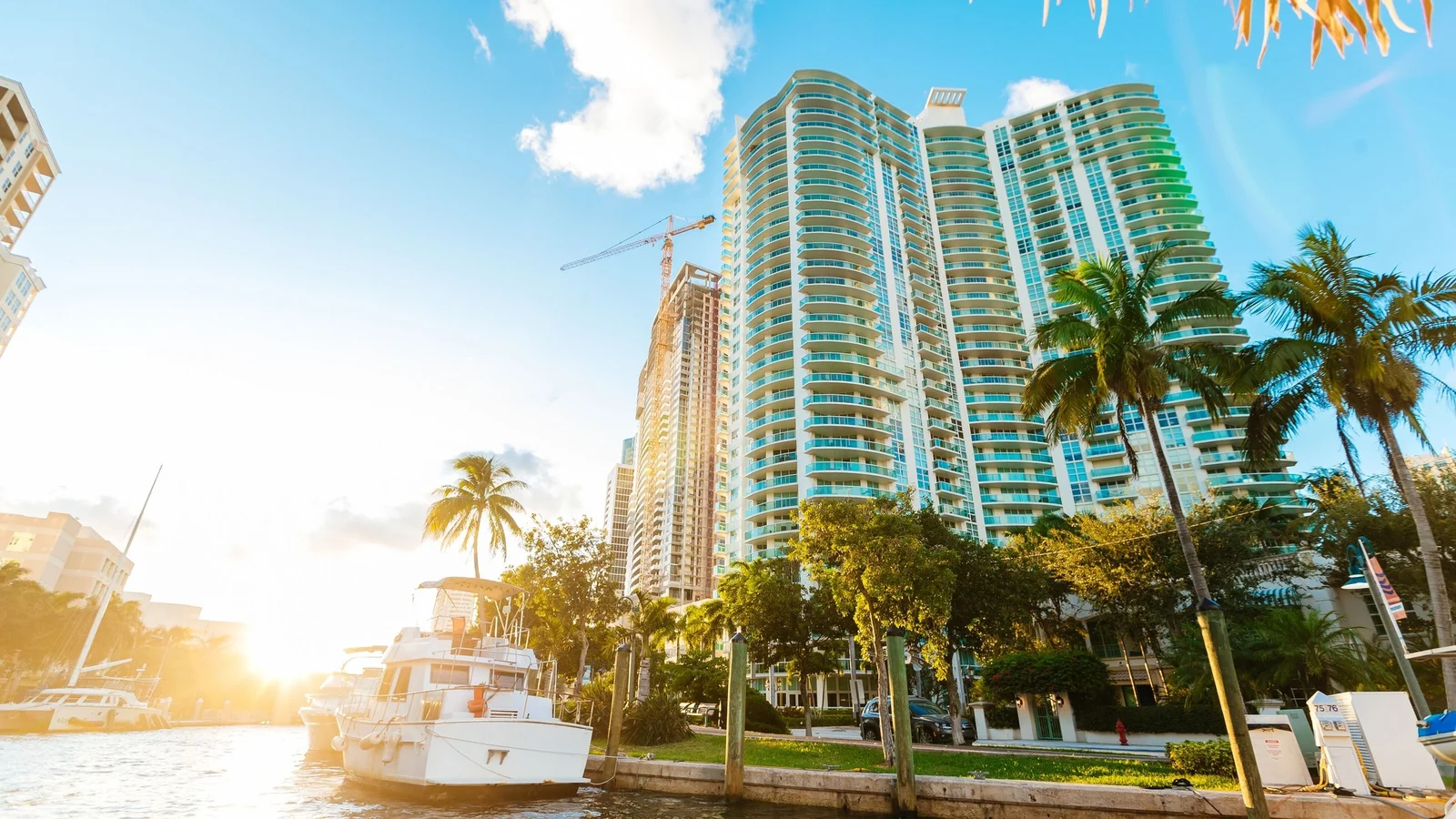 Waterfront condo towers and a crane behind a marina in Fort Lauderdale