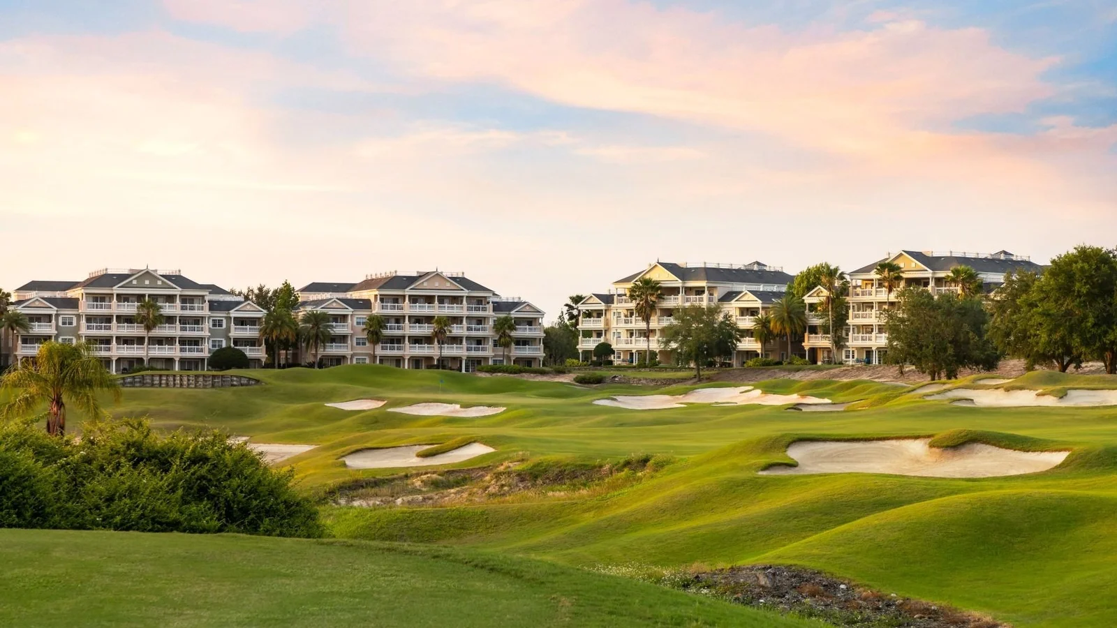 Reunion Resort condo buildings overlooking a golf course with sand bunkers.