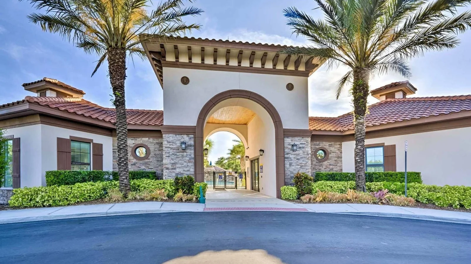 Arched entrance building with a tiled roof and palm trees at Solterra Resort in Davenport.
