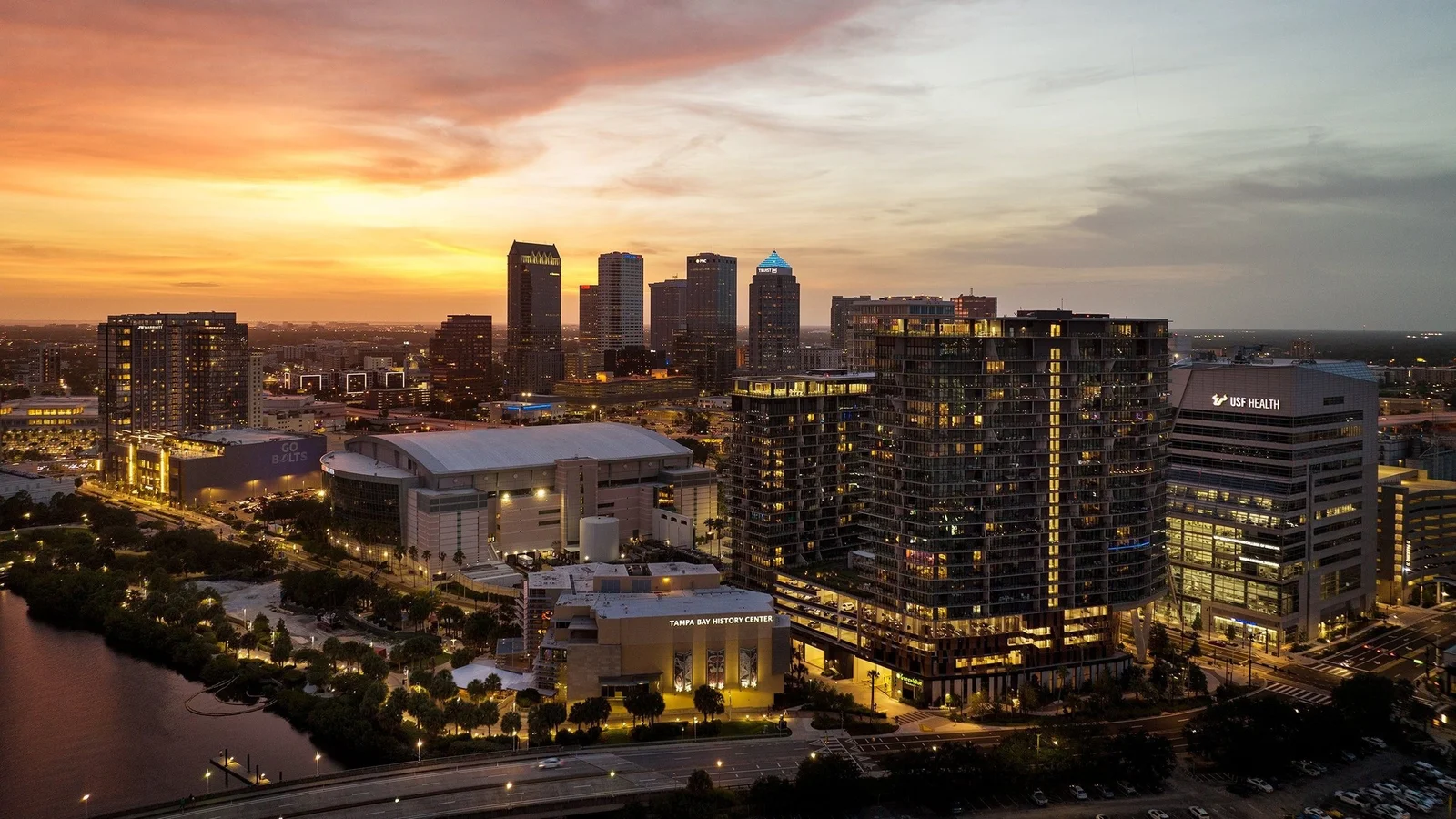 Water Street Tampa at dusk, with its new towers beside Amalie Arena and downtown Tampa behind