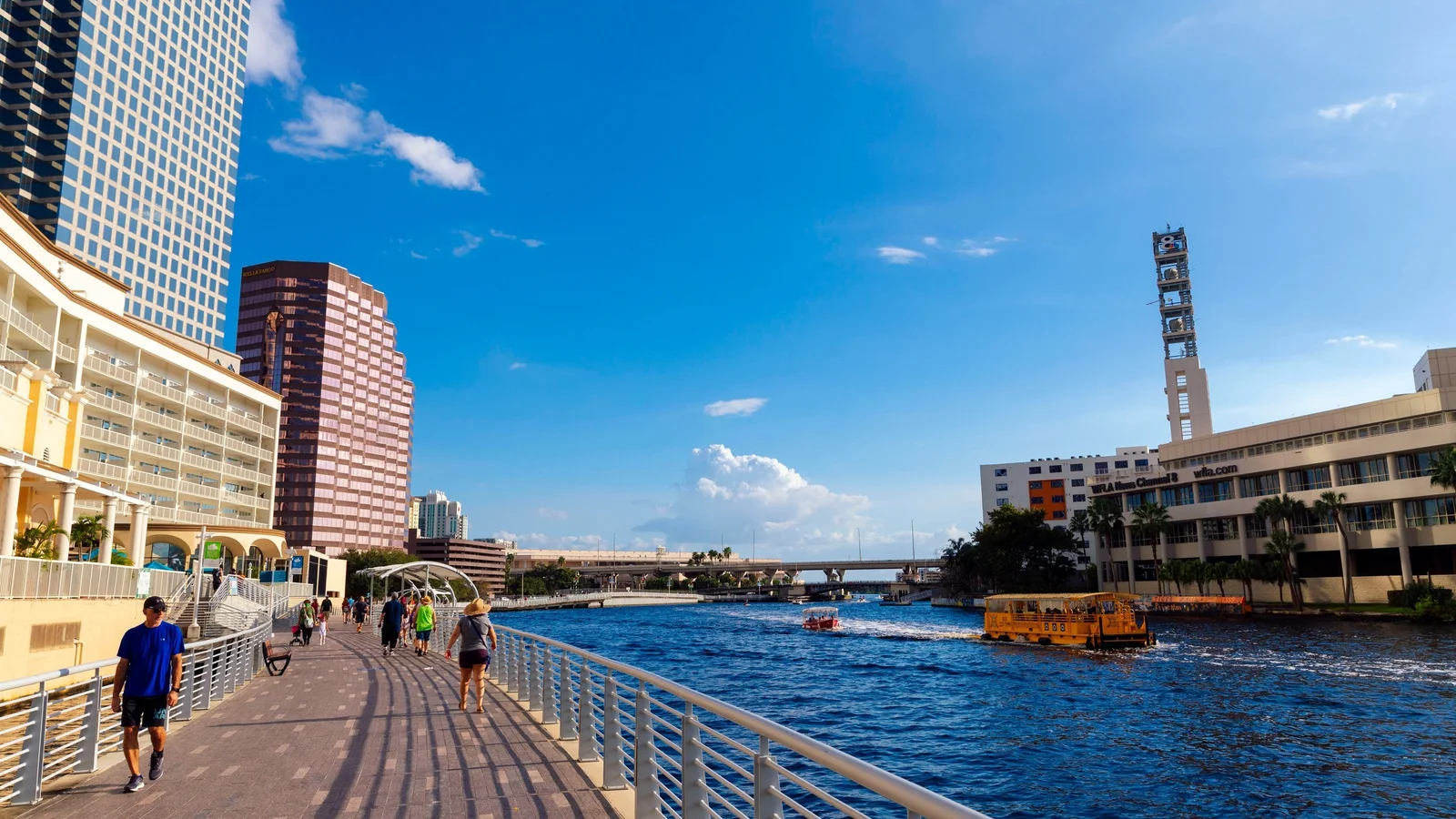 Tampa Riverwalk along the Hillsborough River with downtown towers and a water taxi.