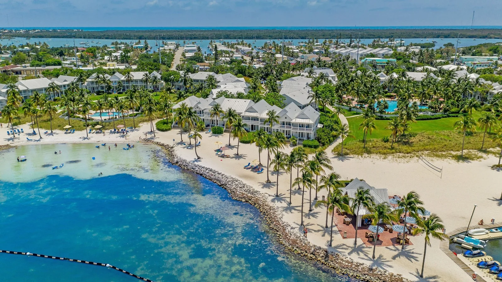 Aerial view of a waterfront resort with a lagoon beach and palm trees in the Florida Keys