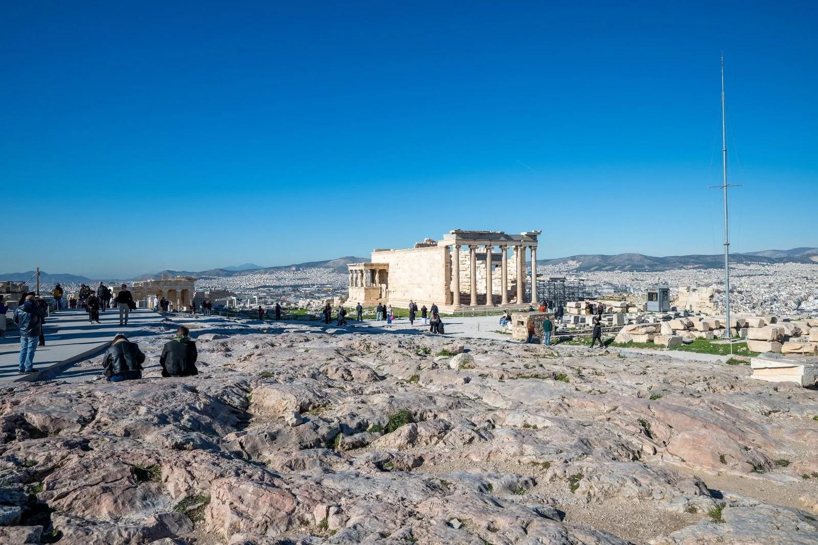 Visitors on the Acropolis plateau beside the Erechtheion