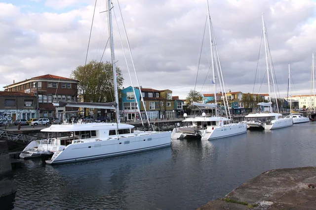 Two cruising catamarans berthed alongside a quay