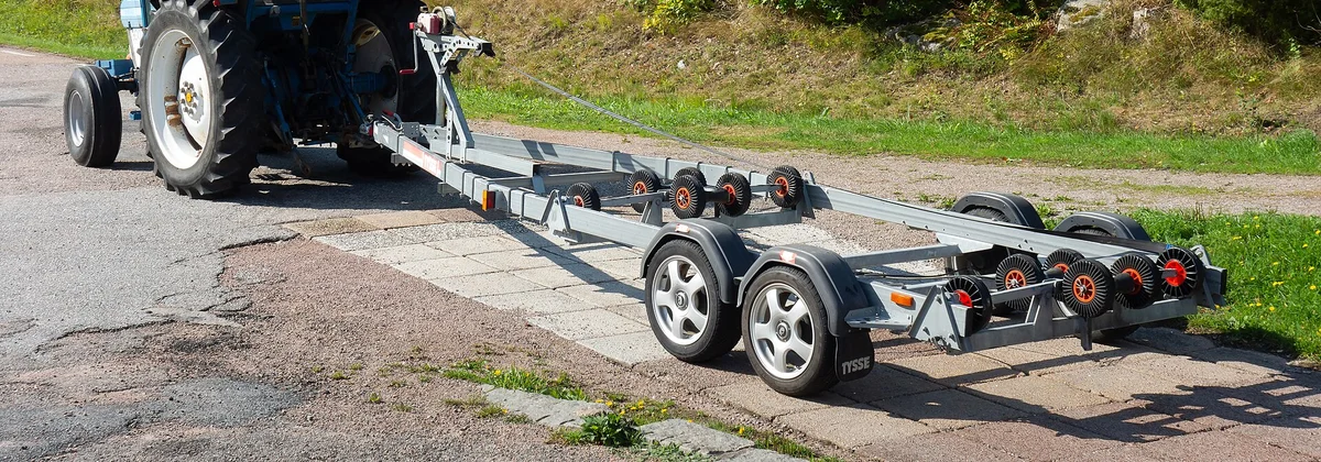 A boat trailer being reversed down a launch ramp