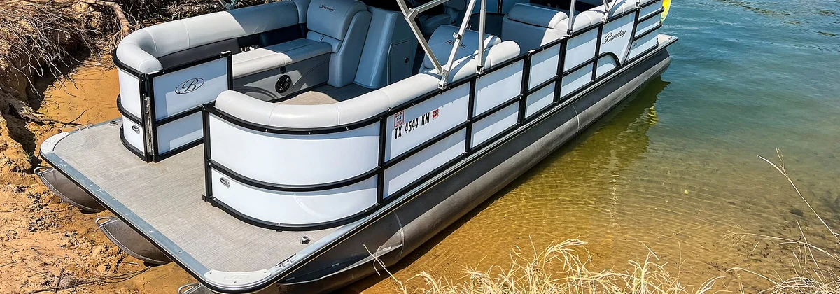 Pontoon boats moored side by side at a lakeside dock
