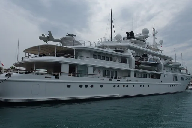 A large explorer yacht with a helicopter on deck