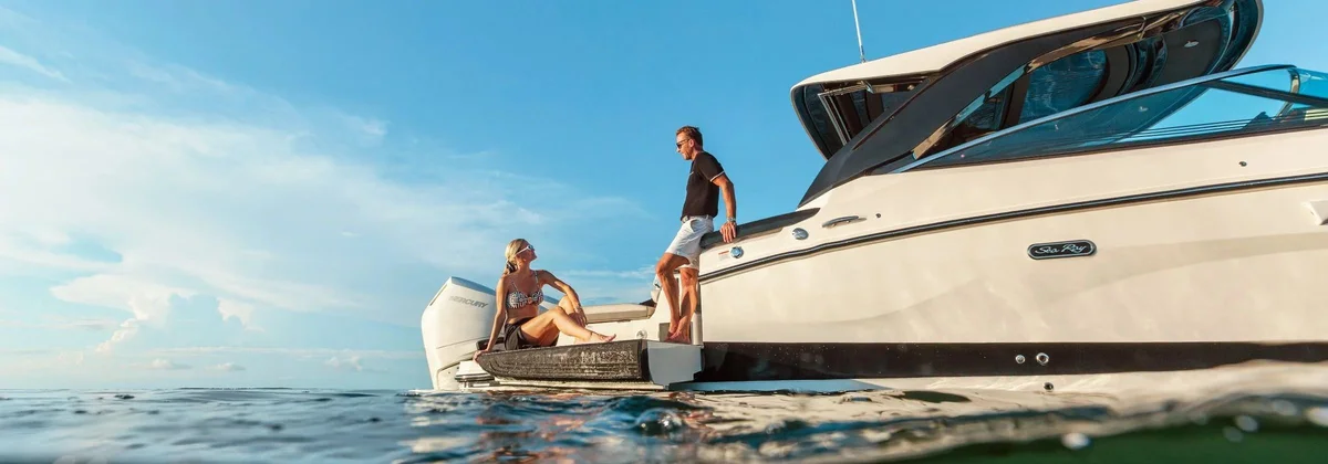 Couple on the swim platform of a Sea Ray SLX 360 at the waterline