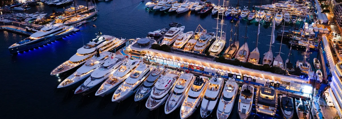 Superyachts lit up at night in Port Hercule during the Monaco Yacht Show