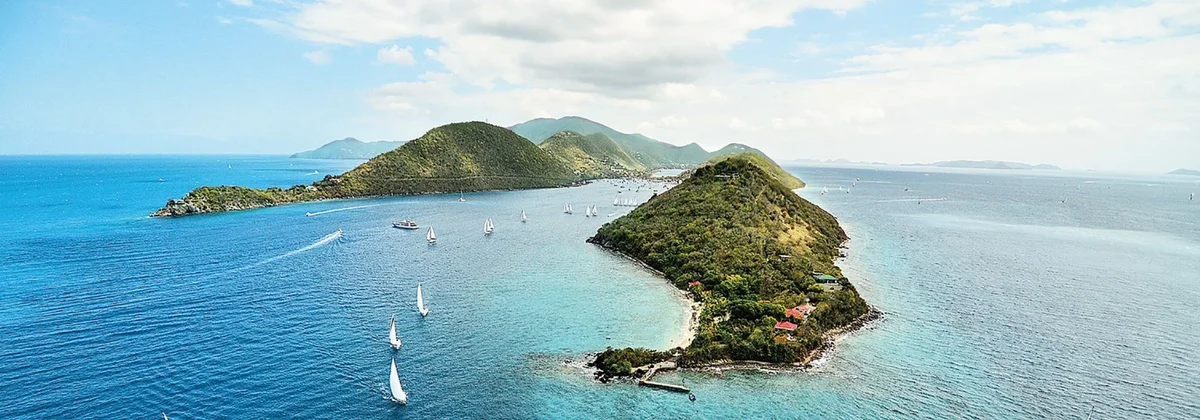Sailing yachts off a green island in the British Virgin Islands