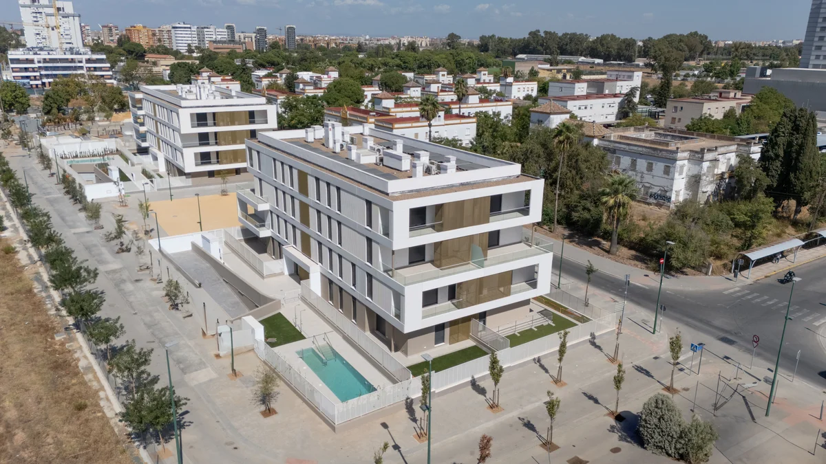Aerial view of Insur Bermes II white apartment blocks with pool in Los Bermejales, Seville