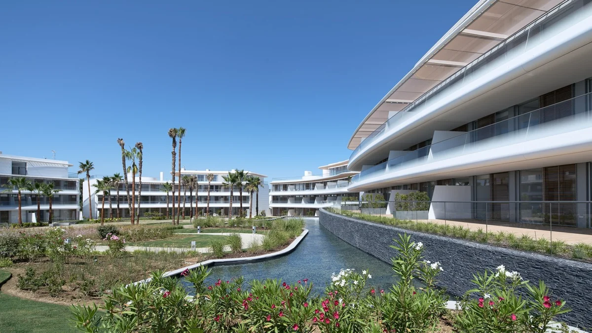 The Edge Estepona by Kronos Homes: curved facades over the garden water canal
